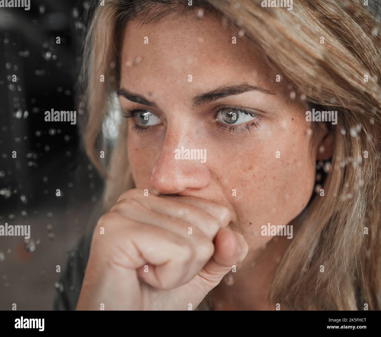 Stress, anxiety and mental health woman by window in house, home and psychology support asylum thinking while watching rain. Zoom, fear face or Stock Photo