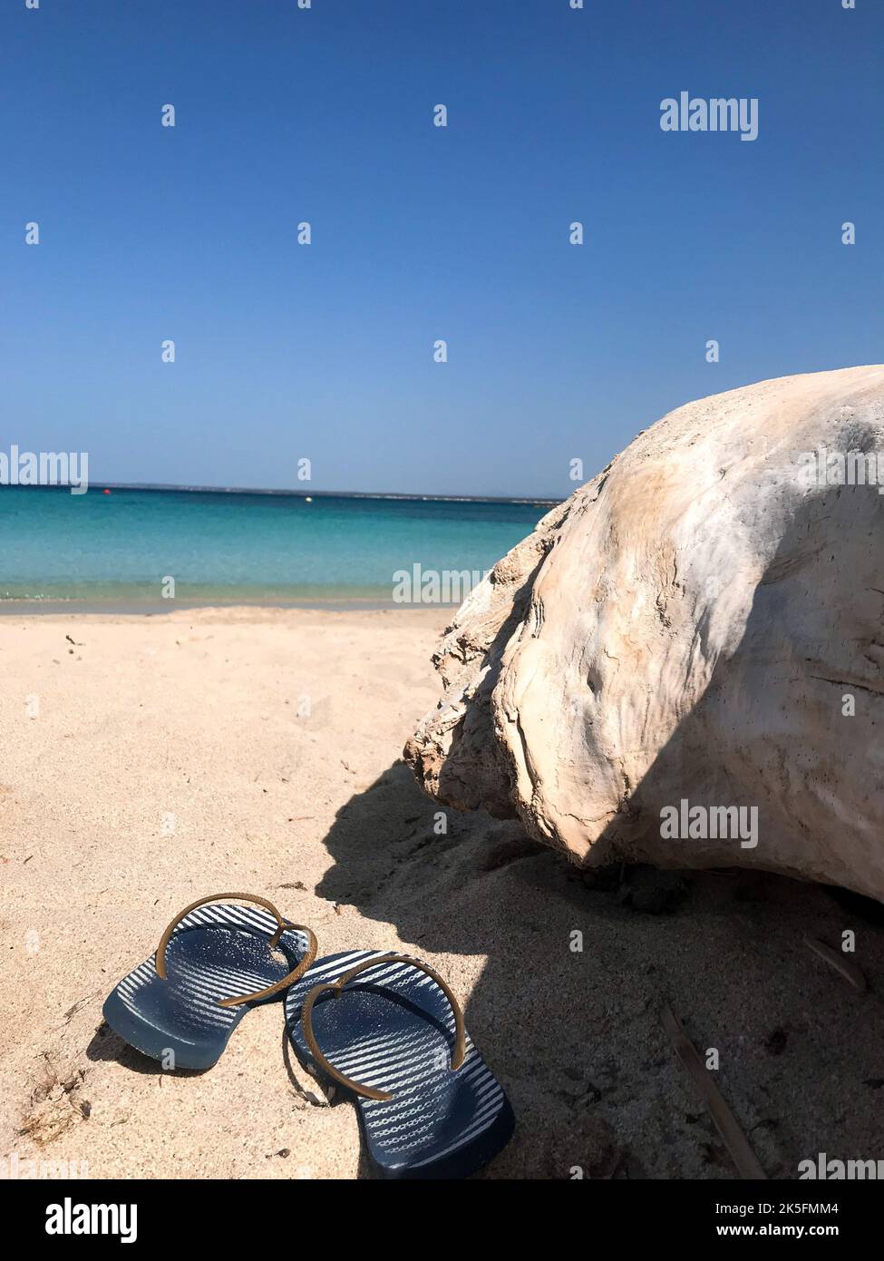 A vertical shot of sandals on the sand at the beach Stock Photo - Alamy