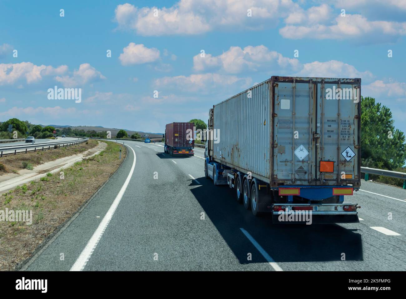 Trucks circulating with containers marked with orange panels, transport ...