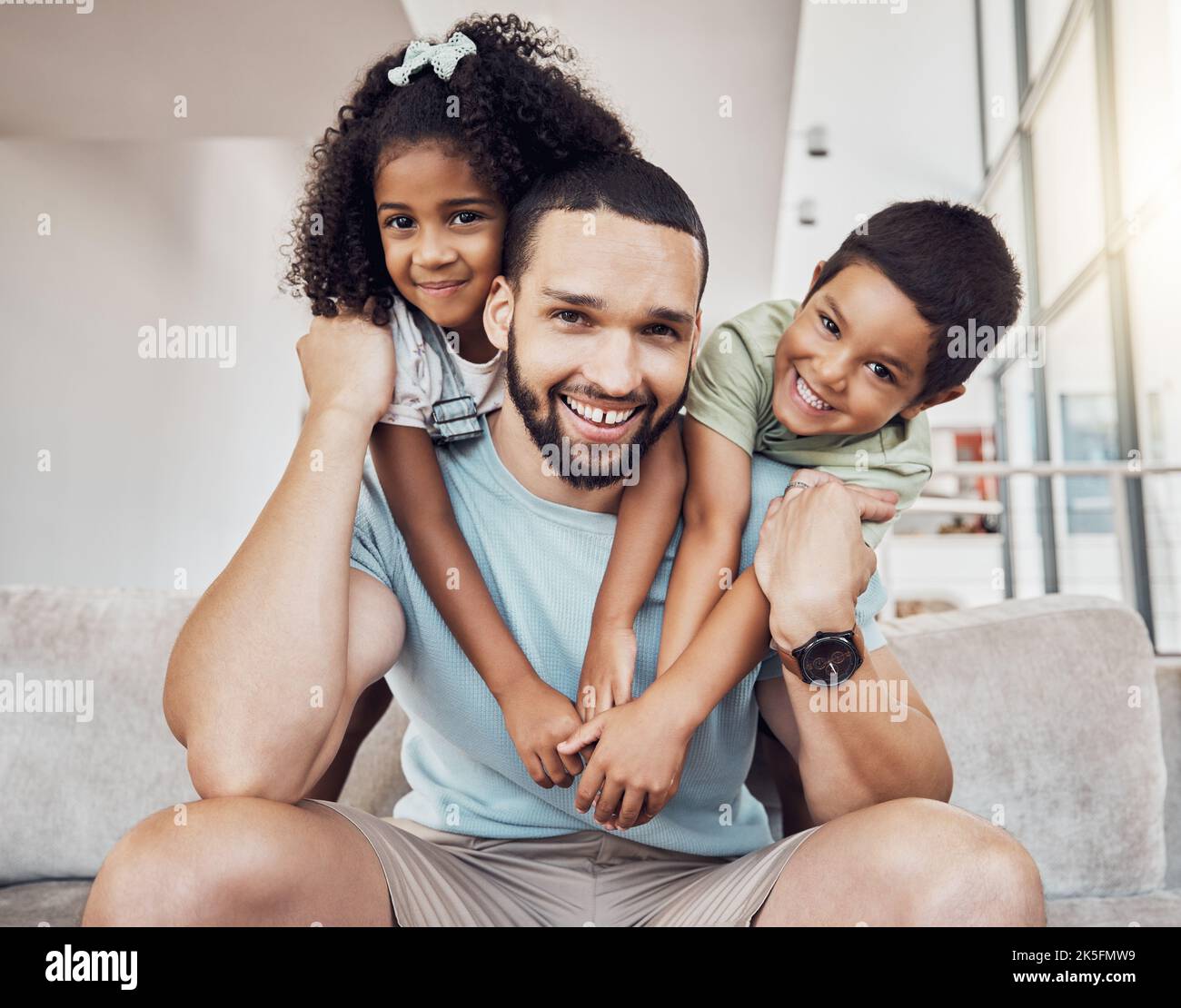 Children happy, home relax and father getting hug from kids on the living room sofa of their house. Portrait of kids and dad hugging for love and Stock Photo