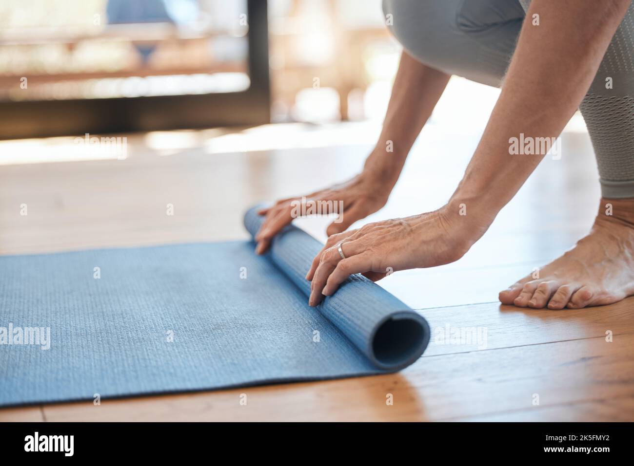 Young slim woman with blonde hair sitting on the yoga mat in split and  training her stretching - using auxiliary stand under the feet Stock Photo  - Alamy