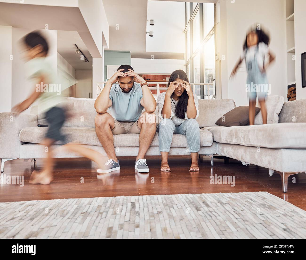 Stress, headache and family with children running in living room with