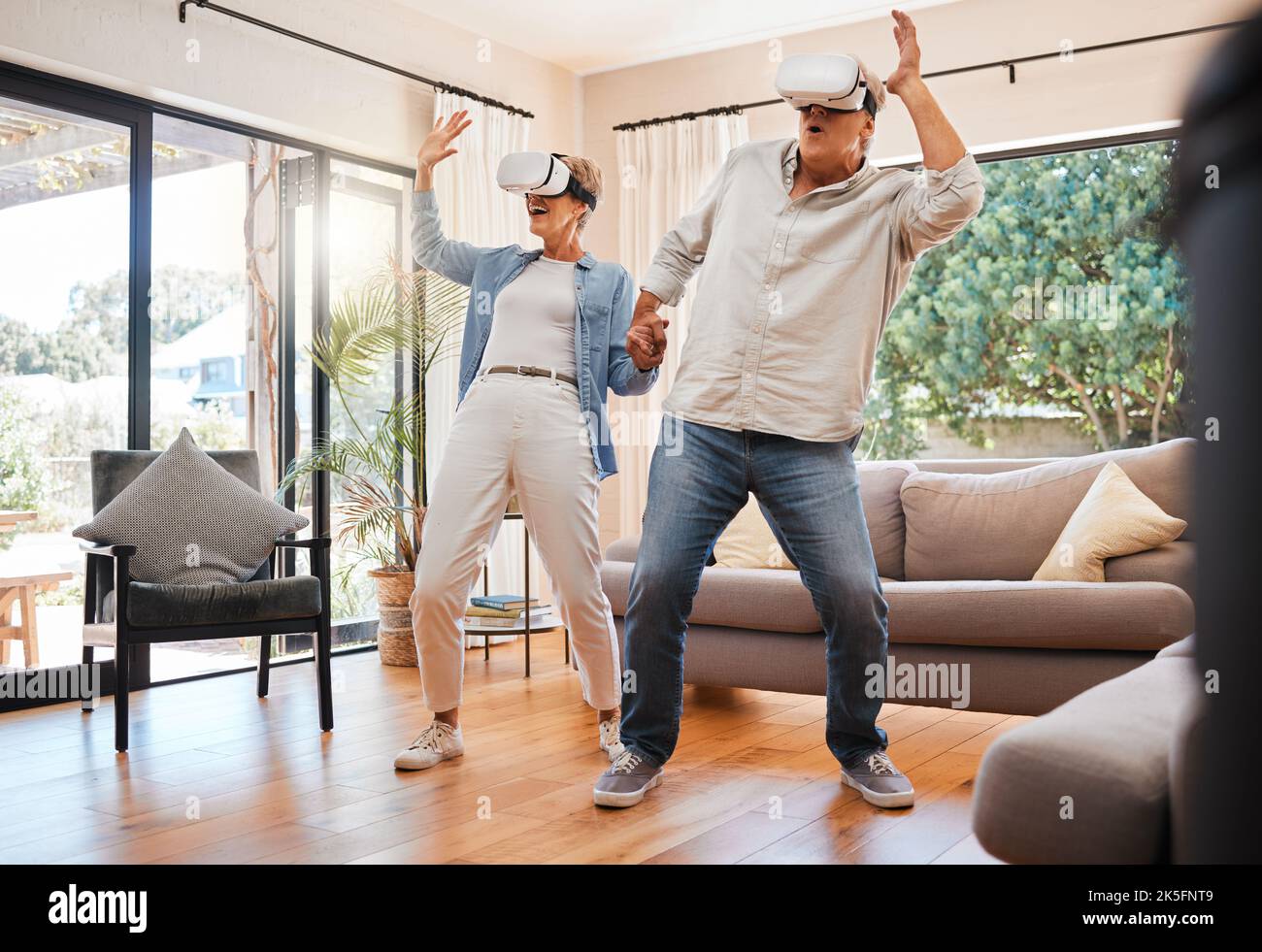 VR experience, senior couple and living room metaverse video games innovation, digital fantasy and cyber connection. Crazy man, happy woman and Stock Photo