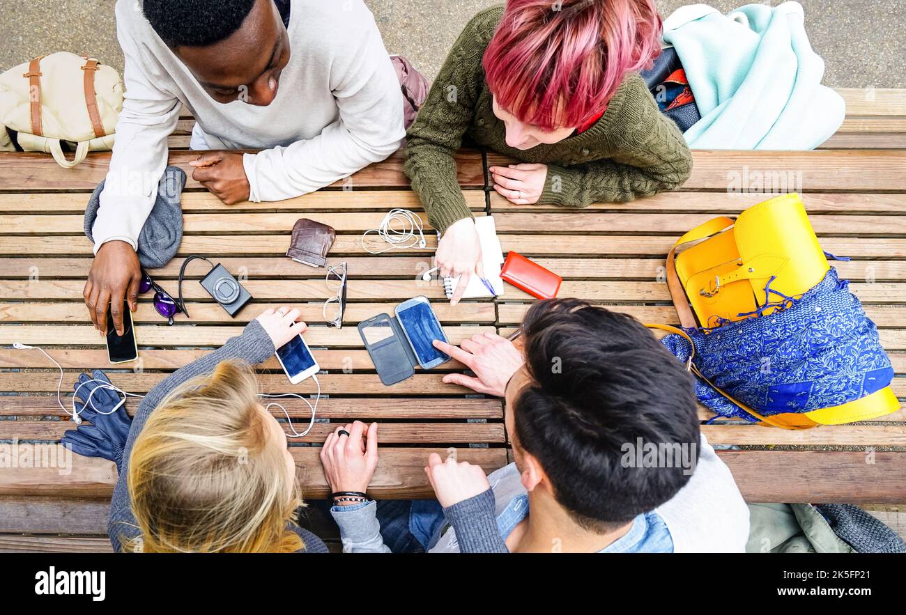 Top view of multiracial friends using mobile smart phone - Addiction concept with young people on new tech devices - Multicultural students having fun Stock Photo