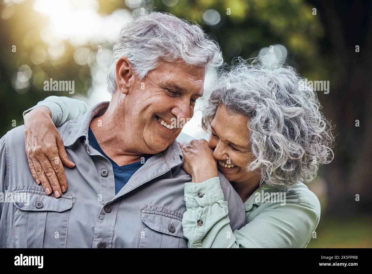 Senior couple smile and happy with conversation outdoor at a forest, care and love. Elderly man and woman talking, laugh and peaceful day in nature Stock Photo