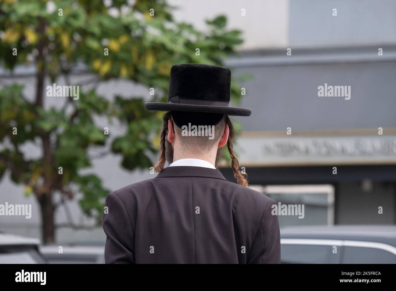 A generic photo of an anonymous hasidic Jewish man with long peyes and wearing a black hat. On Bedford avenue in Williamsburg, Brookly, New York Citry. Stock Photo