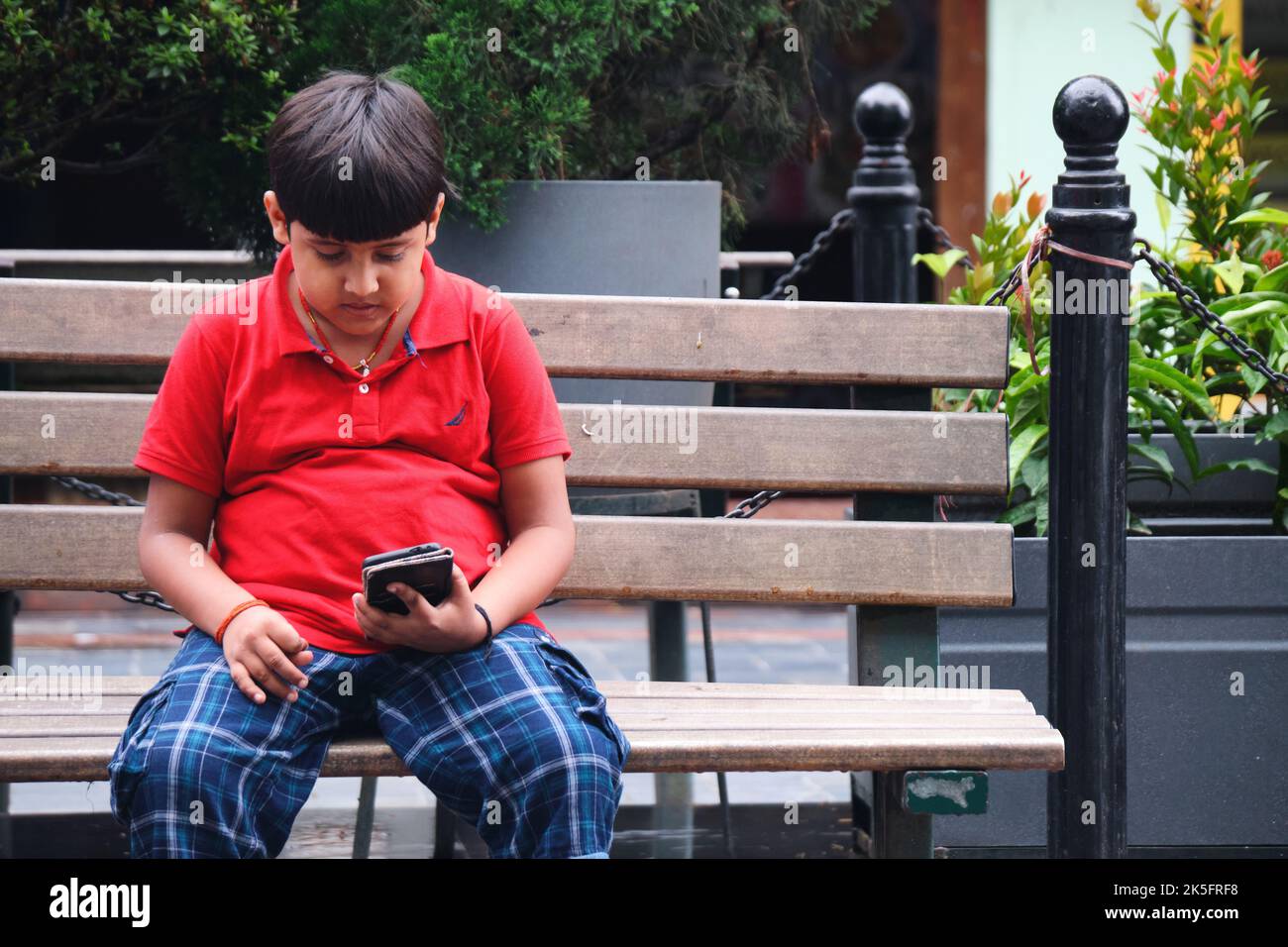21 June 2022, Gangtok, Sikkim, India, Little Indian kids playing with cellphone in MG Road Market. Stock Photo