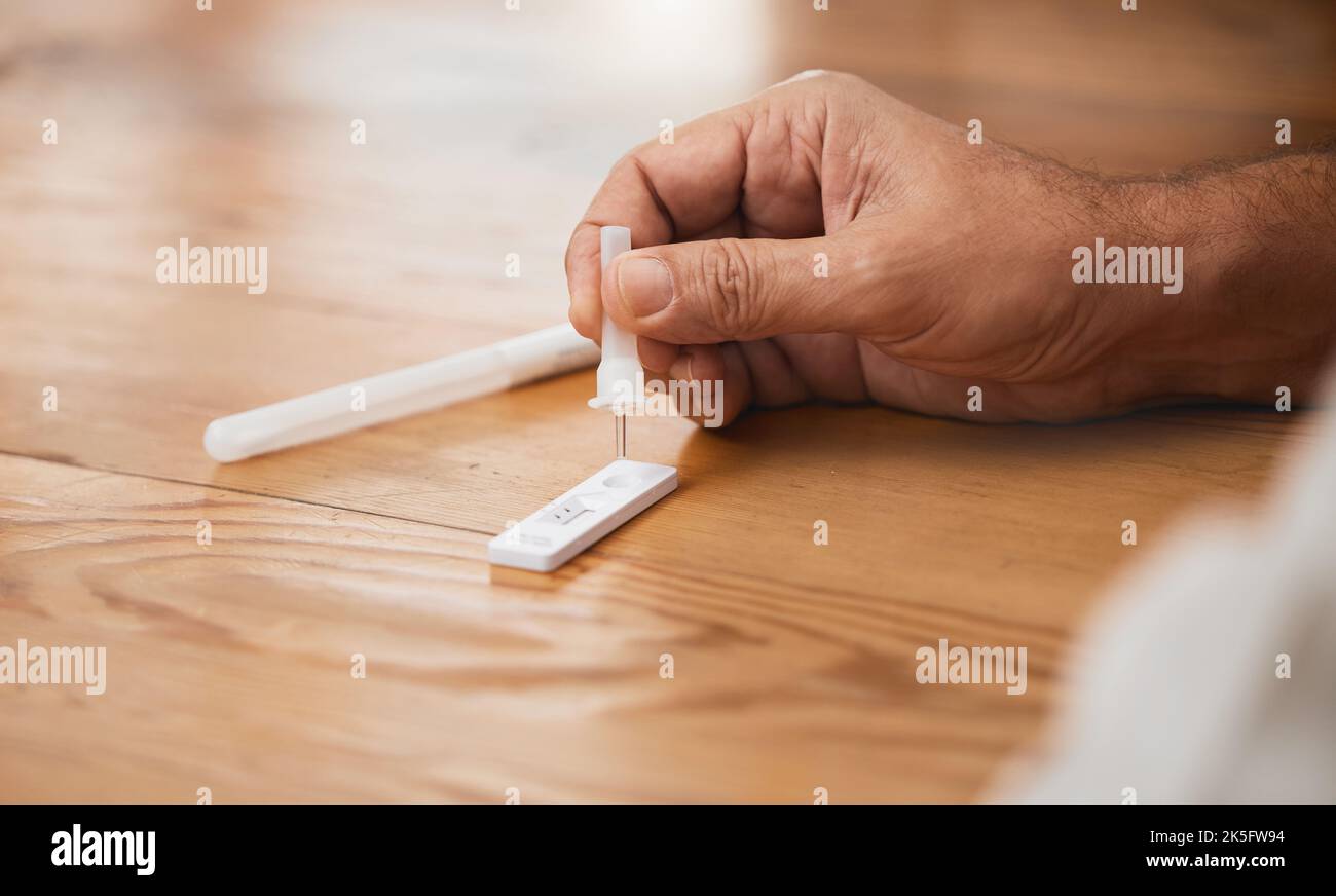 Hands, covid antigen test or dropper in home kit, house or living room for healthcare insurance or medical virus disease. Zoom, man or pcr covid 19 Stock Photo