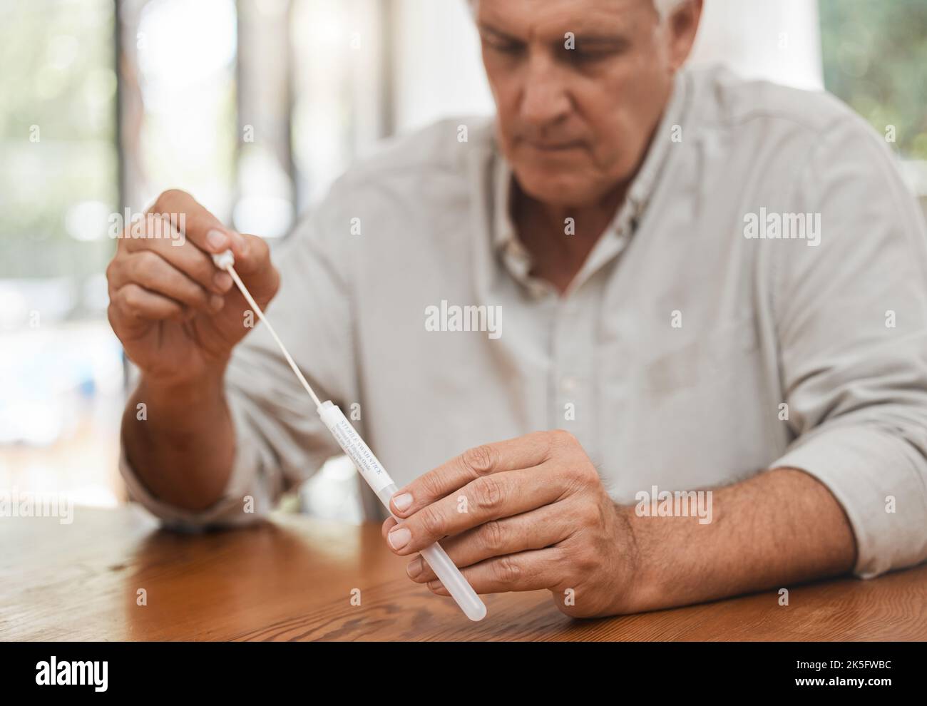 Mature man, covid pcr test or swab for mouth or nose in home kit, house or living room for healthcare insurance or medical virus disease. Zoom, hands Stock Photo