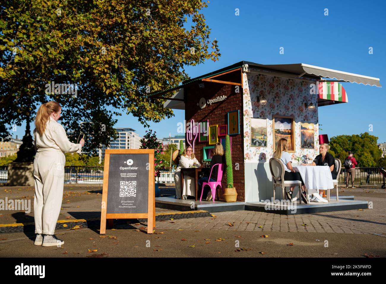 EDITORIAL USE ONLY A passerby uses QR code to book OpenTable's popup