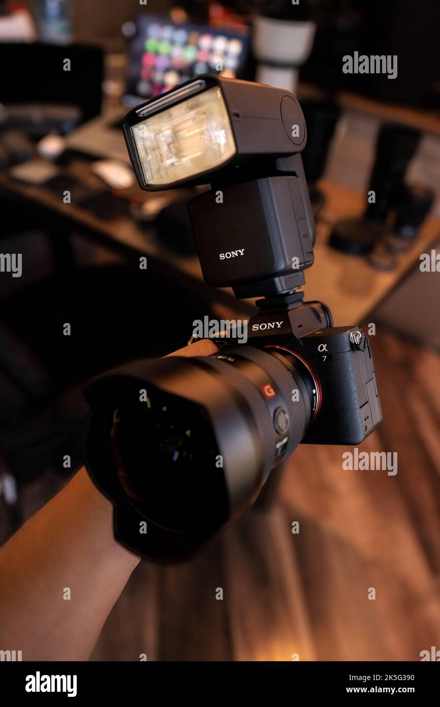 A vertical closeup of the Sony A7IV camera with flash and GM lens Stock
