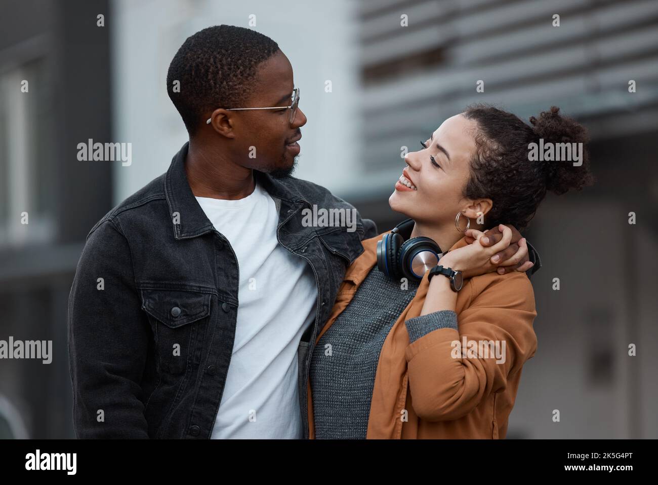 Young couple walking in the city on the street, holding hands and in love. Dating, love and black woman with black man in multicultural relationship Stock Photo