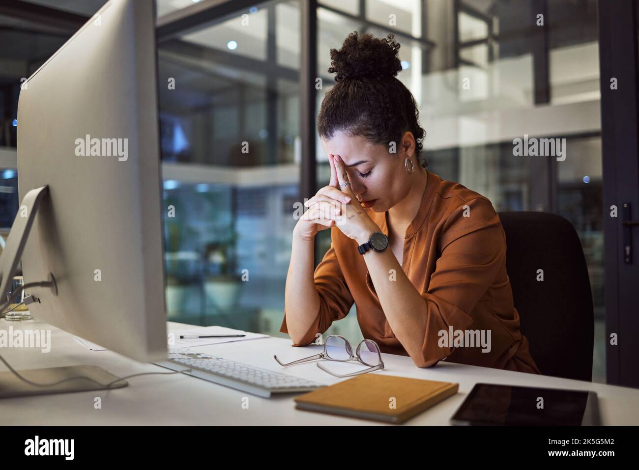 Headache, business woman at night and computer stress while working for a deadline with pc glitch. Sad corporate manager with anxiety about target Stock Photo