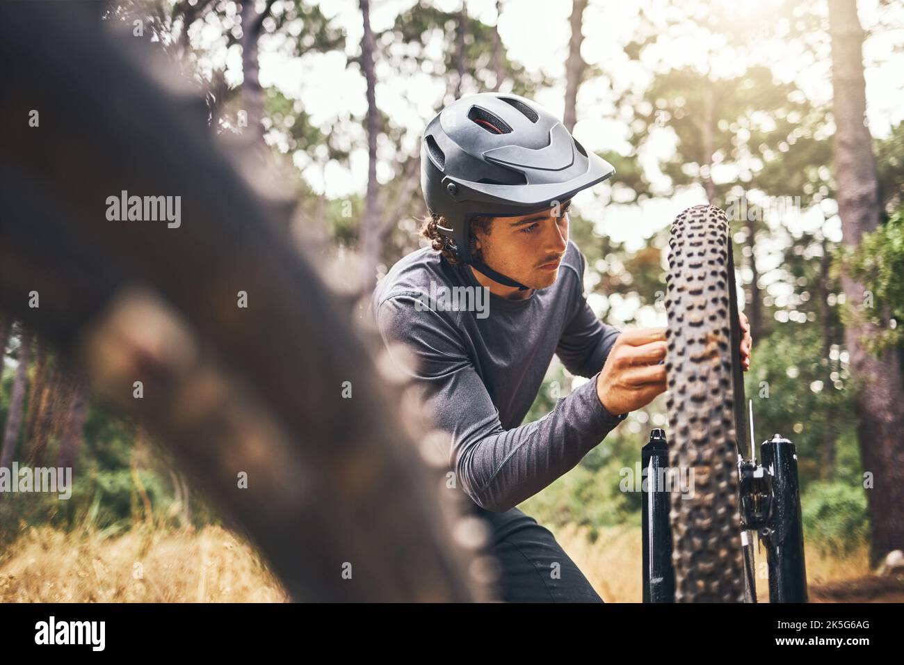 Cycling, adventure trail and bike repair, man fix wheel in forest. Nature, mountain biking and cyclist, outdoor cycle maintenance in Australia Stock Photo
