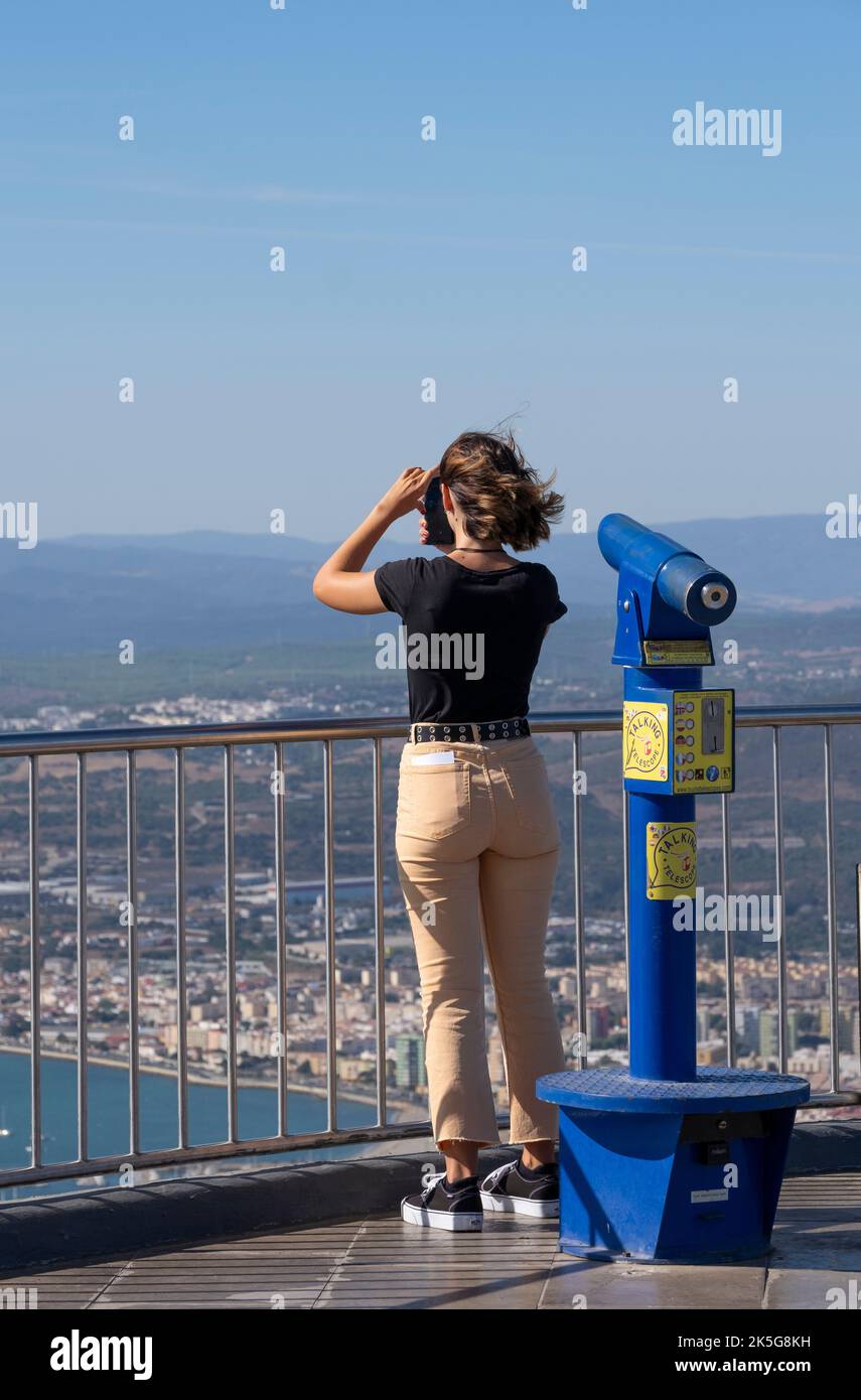 Tourist taking photos on the viewing platform at the Cable Car top station, which is located on the Upper Rock Nature Reserve at Gibraltar. Stock Photo