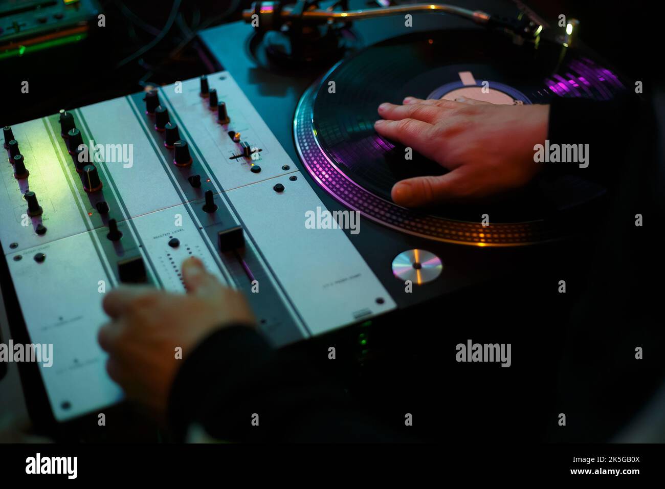 Hip hop dj scratching vinyl record with music on party in night club