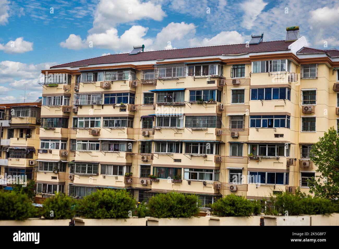 Nanjing, Jiangsu, China.  Apartment Building with Individual Air Conditioners for Each Flat.  Note Solar Water Heaters on Roof. Stock Photo