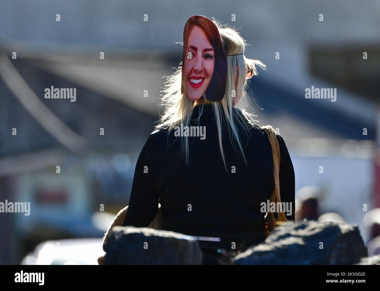 Cheddar, UK. 08th Oct, 2022. A person with friends one seen in Cheddar Gorge near shops wearing a LIZ TRUSS look alike mask on the back of her HEAD. Picture Credit: Robert Timoney/Alamy Live News Stock Photo