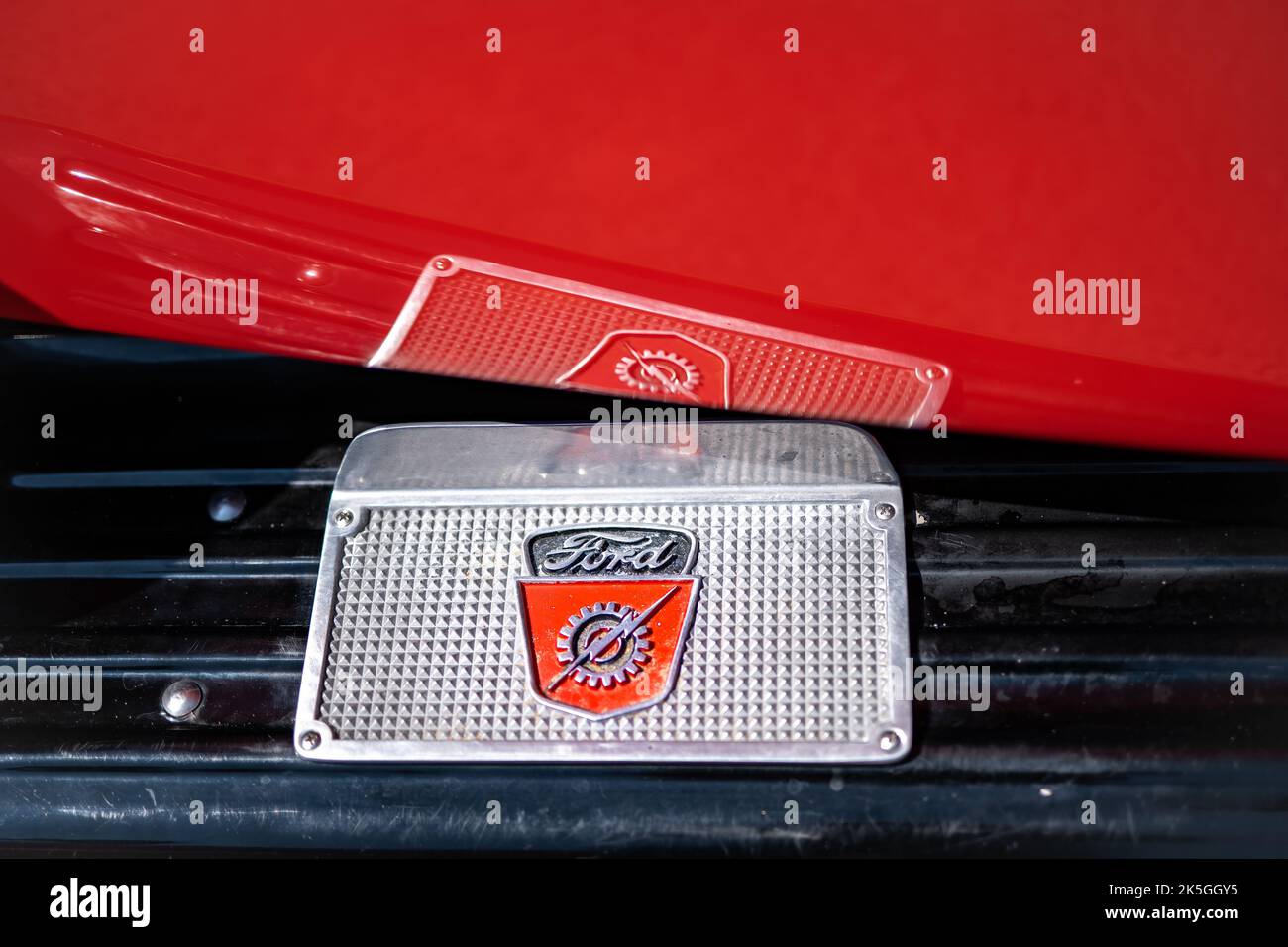 NISSWA, MN â€“ 30 JUL 2022: Closeup of running board of a restored antique Ford pickup truck, with brand emblem logo, and reflection in the bright red painted door panel. Stock Photo