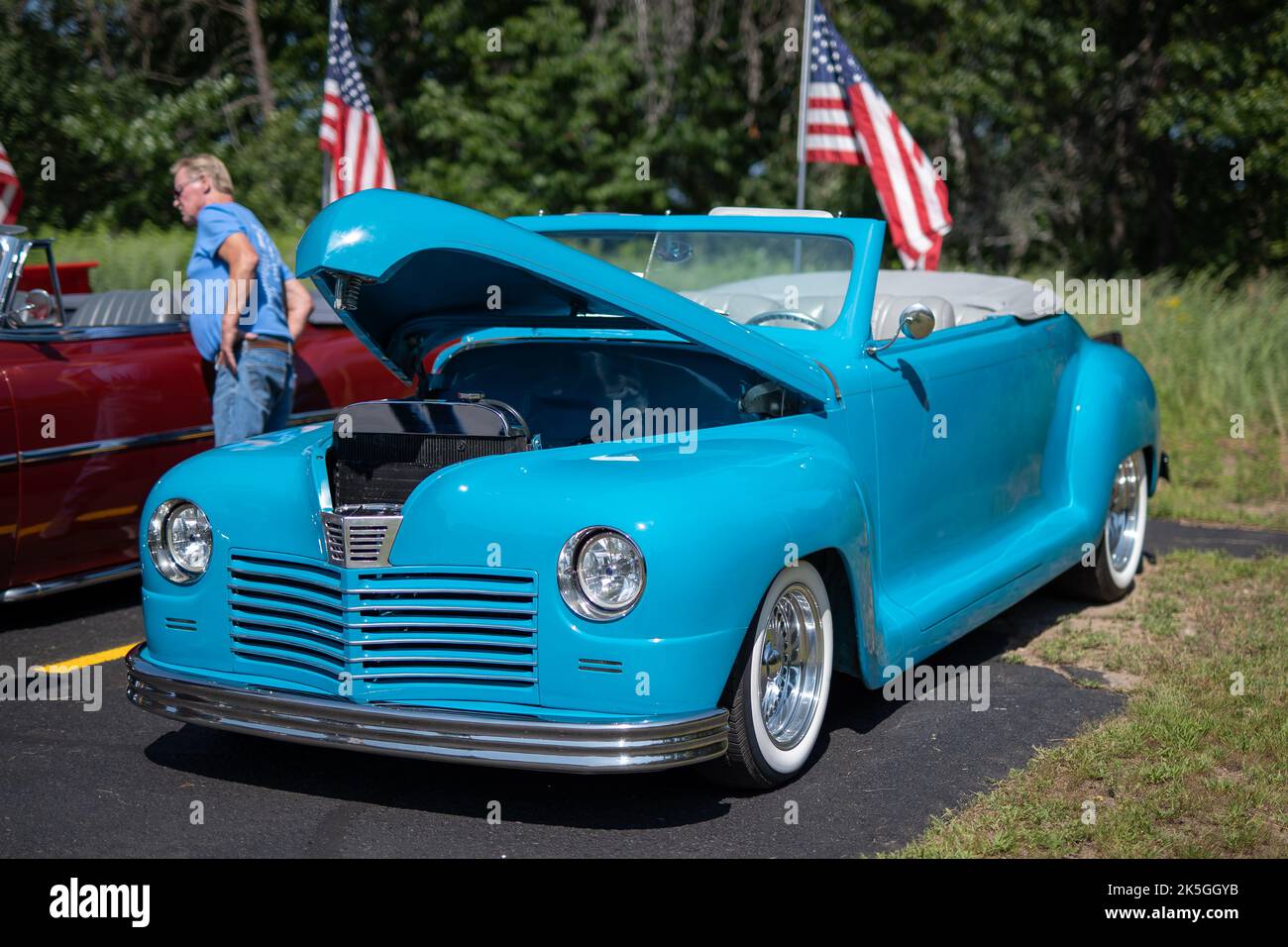 NISSWA, MN â€“ 30 JUL 2022: Vivid sky blue antique vintage convertible automobile with the top down and an open hood, at a car show in Minnesota in bright sunlight. Stock Photo