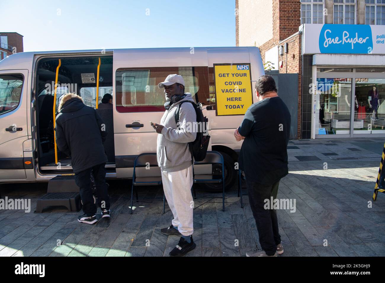 Slough, Berkshire, UK. 8th October, 2022. People were queuing to have their Covid-19 booster jabs today in Slough High Street at a mobile NHS vaccination service. Patients did not have to pre book an appointment for the service provided by Frimley Heath. The vaccine being administered by the NHS today was the Moderna vaccine which is a Spikevax bivalent Original/Omicron. Half of the vaccine (25 micrograms) targets the original virus strain from 2020 and the other half (25 micrograms) targets Omicron. Credit: Maureen McLean/Alamy Live News Stock Photo