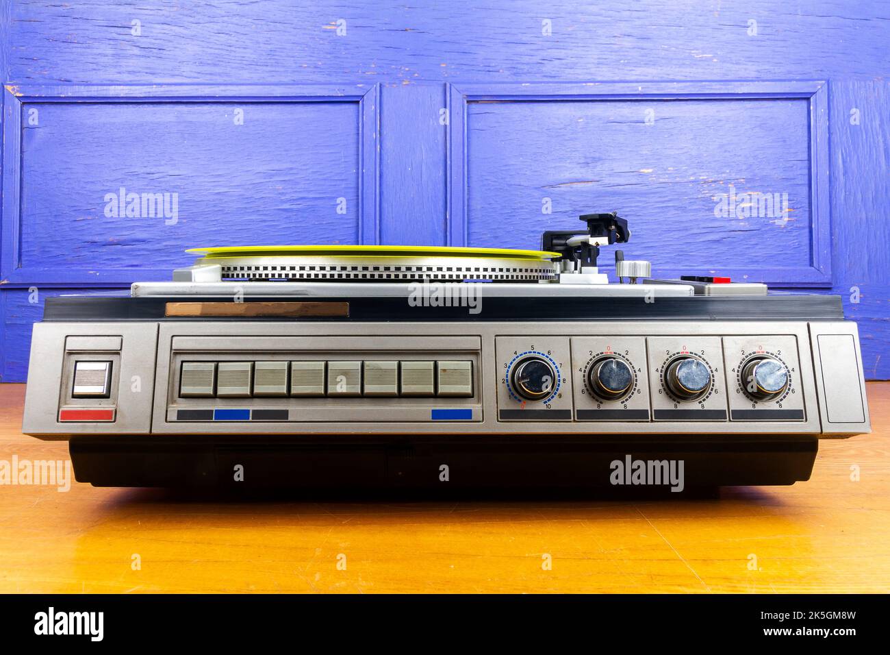 Vintage turntable vinyl record player with yellow vinyl on a table ...