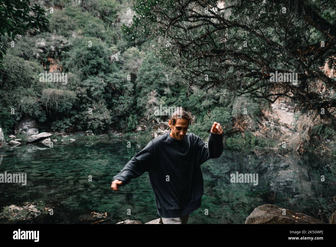 caucasian young man jumping agile and happy between the stones and ...