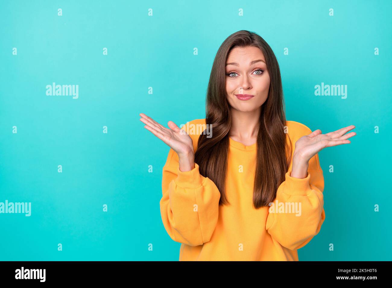 Photo of pretty lady shrugging shoulders dont know answer isolated on cyan color background Stock Photo