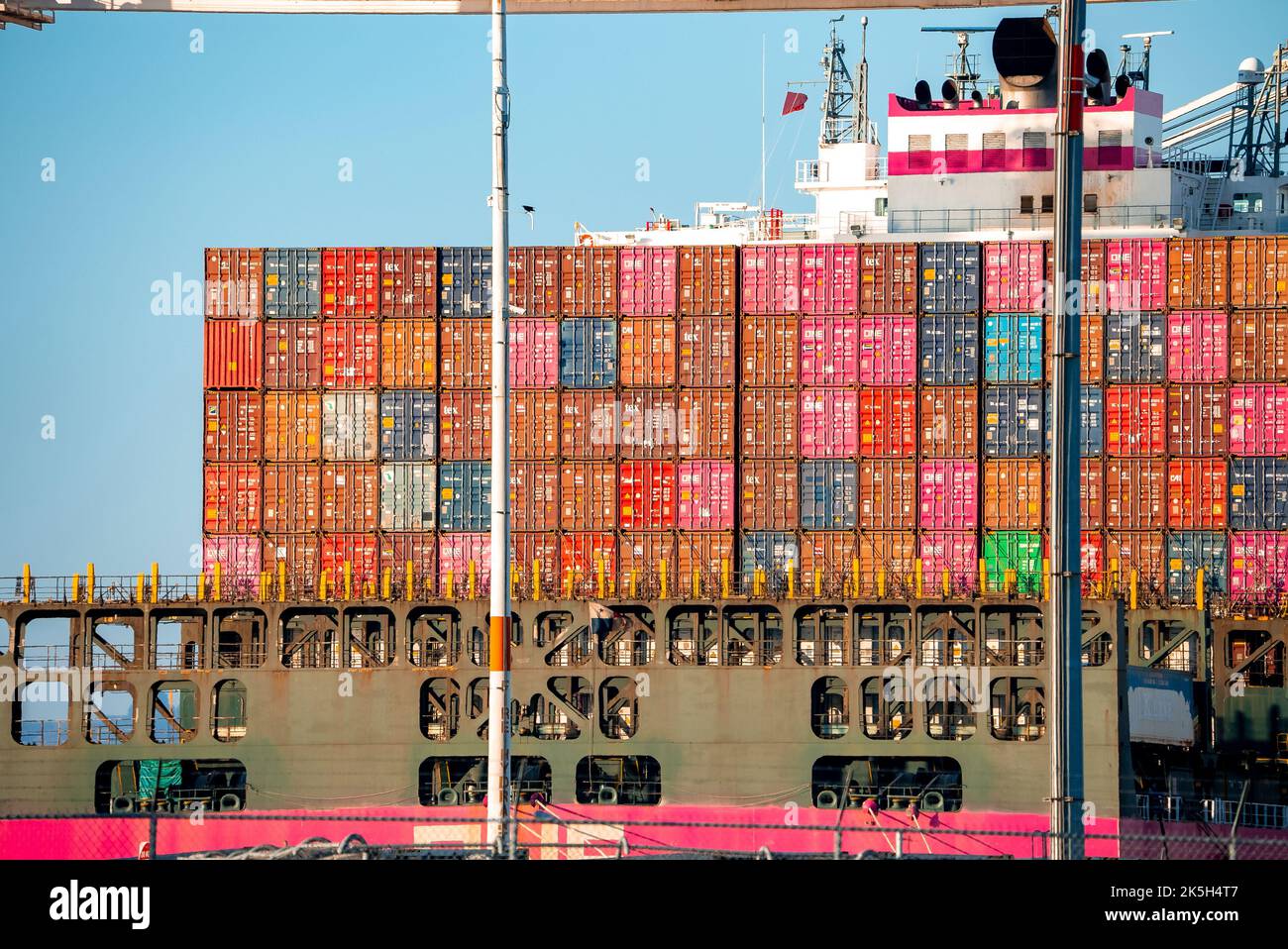 Multicolored containers loaded on ship at Port of Oakland with sky in background Stock Photo