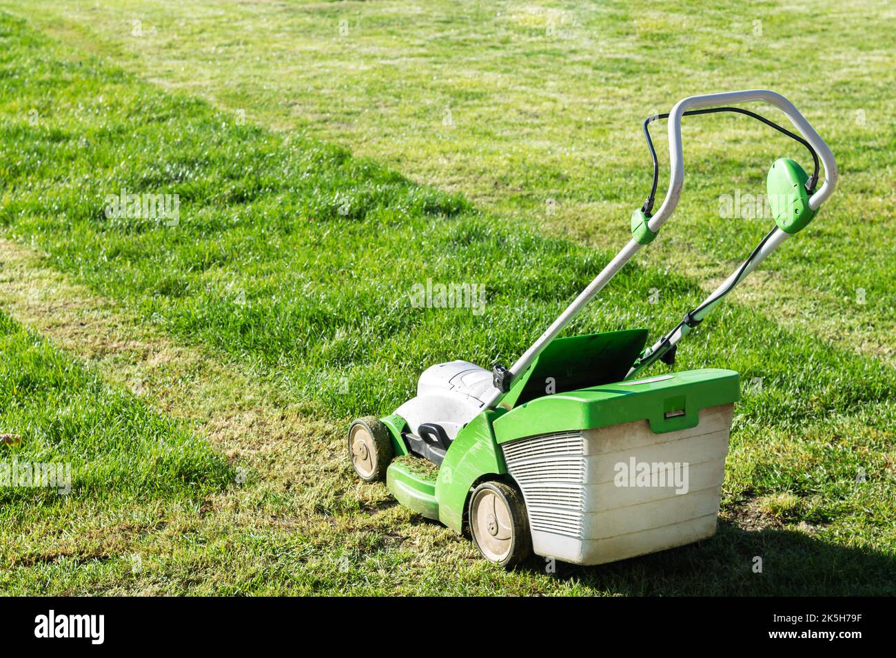 Lawn mover on green grass in summer garden. Machine for cutting grass Stock Photo