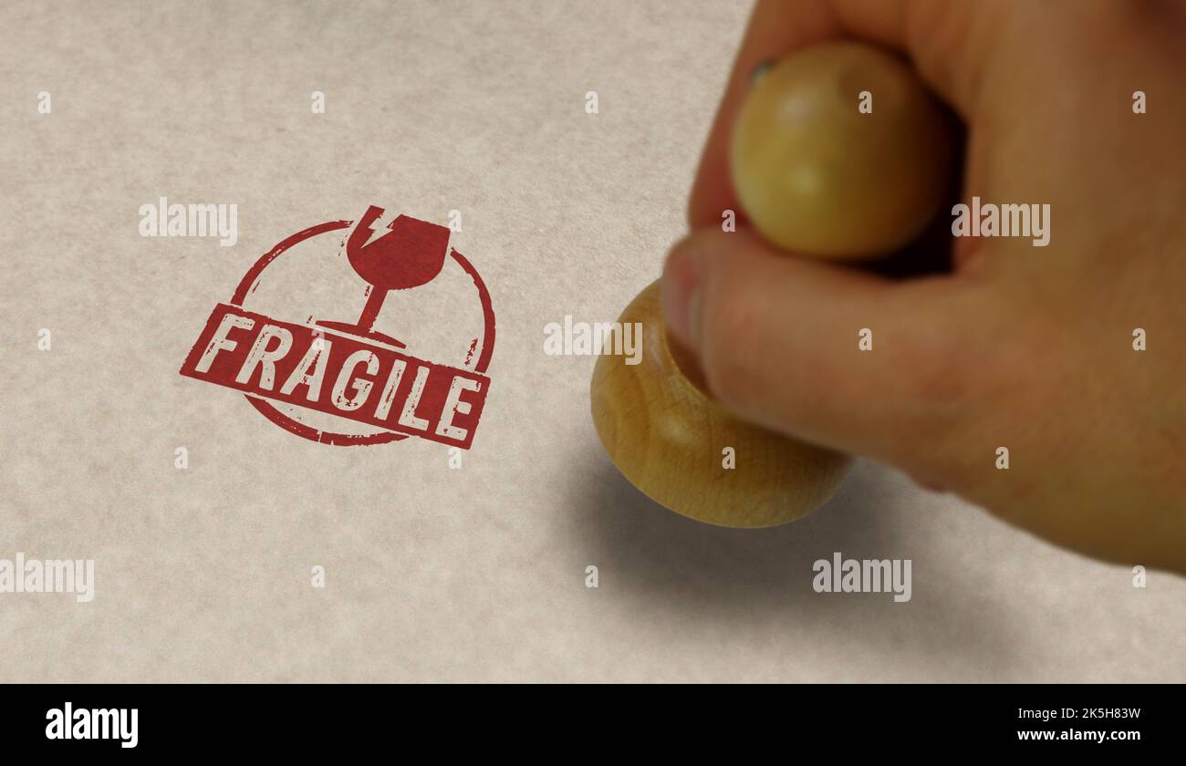 Fragile stamp and stamping hand. Careful shipping and handle with care concept. Stock Photo