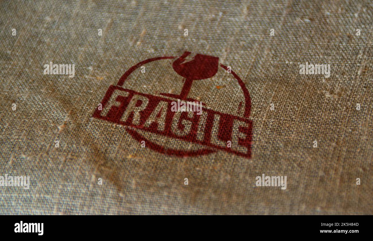 Fragile stamp printed on linen sack. Careful shipping and handle with care concept. Stock Photo