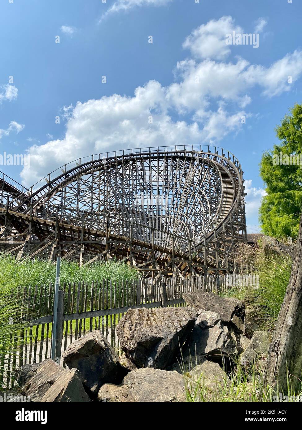 Coaster Carrying Rocksa A vertical shot of a high scary roller coaster in a park surrounded by ...