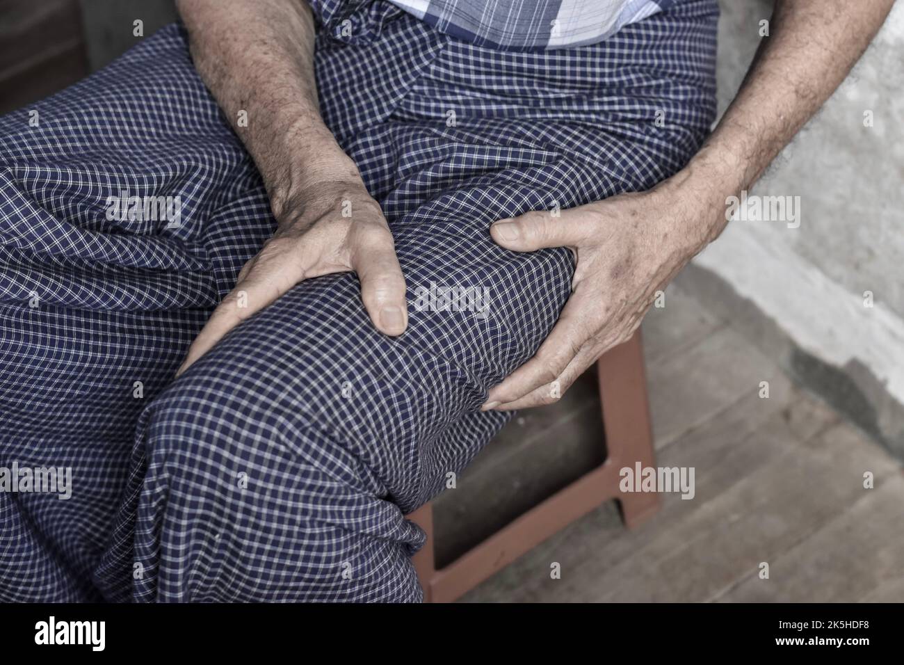Thigh pain in Asian senior male patient. Concept of sciatica or sciatic