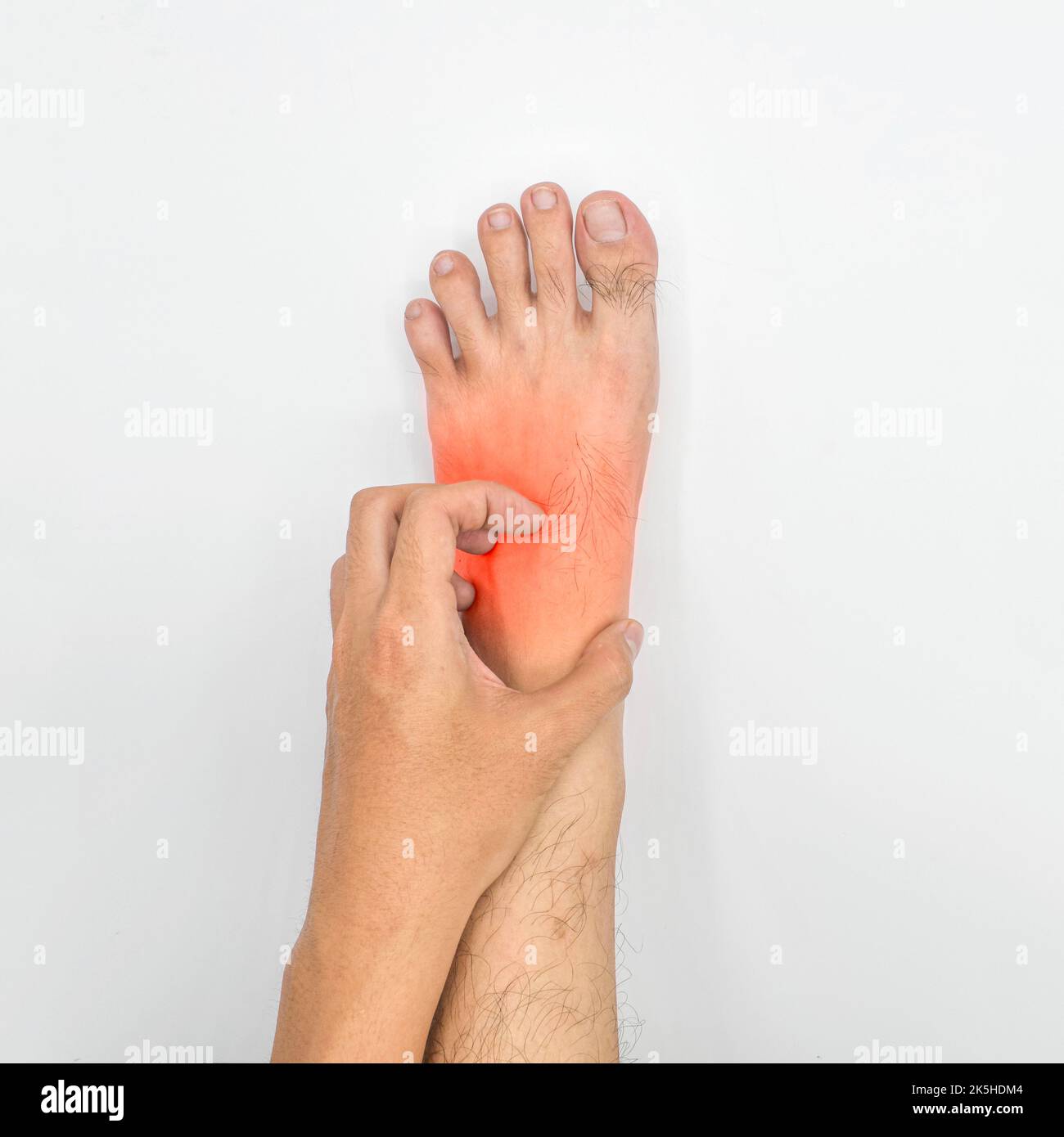 Asian young man scratching his foot. Concept of itchy skin diseases such as scabies, fungal infection, eczema, psoriasis, allergy, etc. Stock Photo