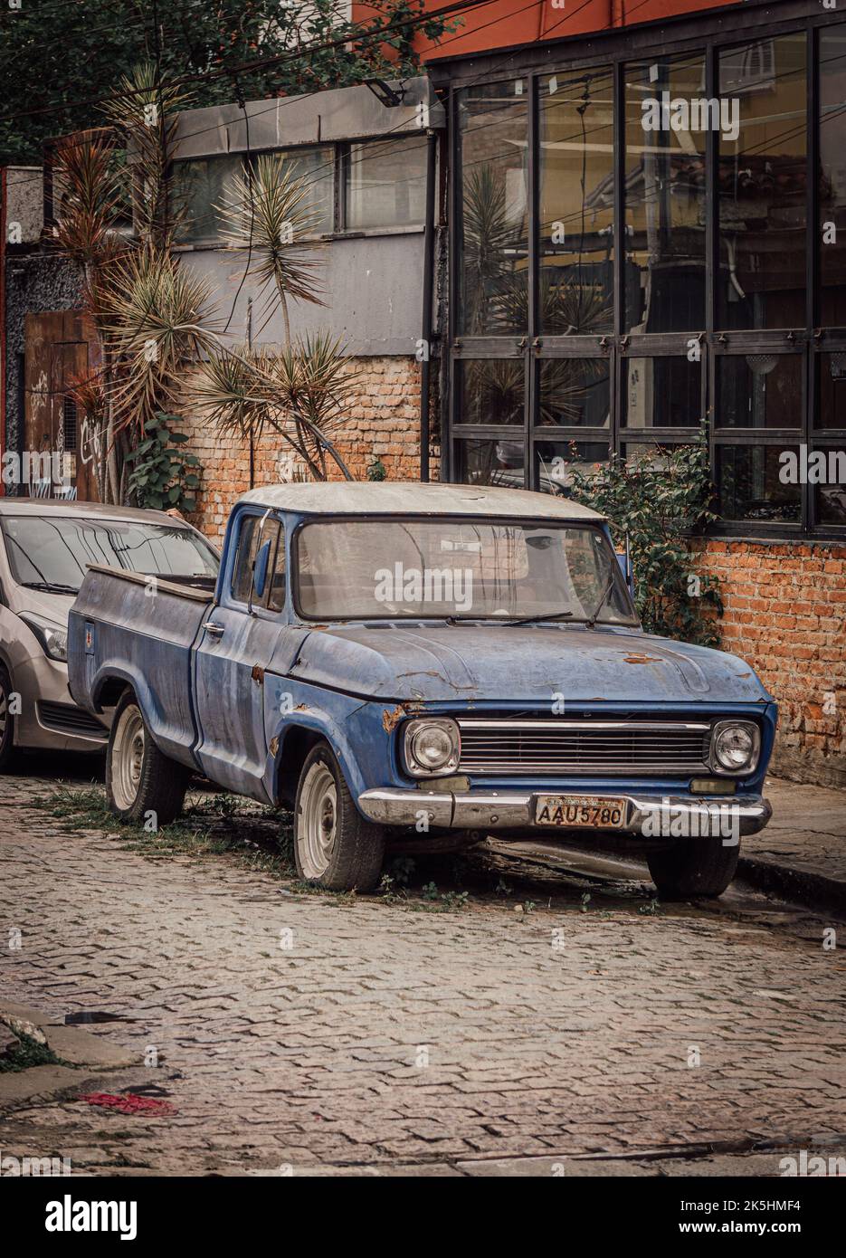 A vertical shot of an old classic car parked in the street of Sao Paola ...