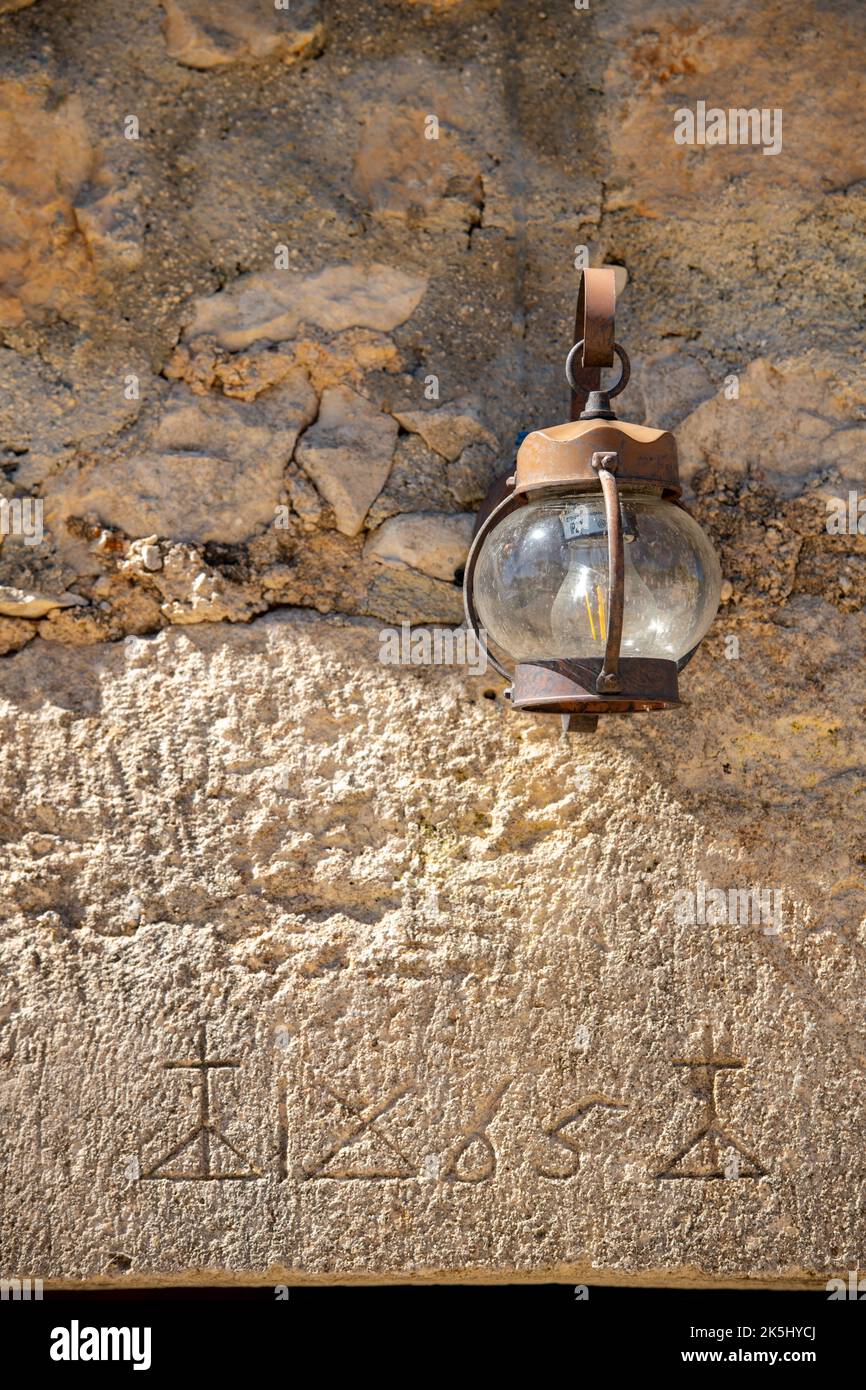 rusty old decorative lantern hanging on a stone wall. Stock Photo