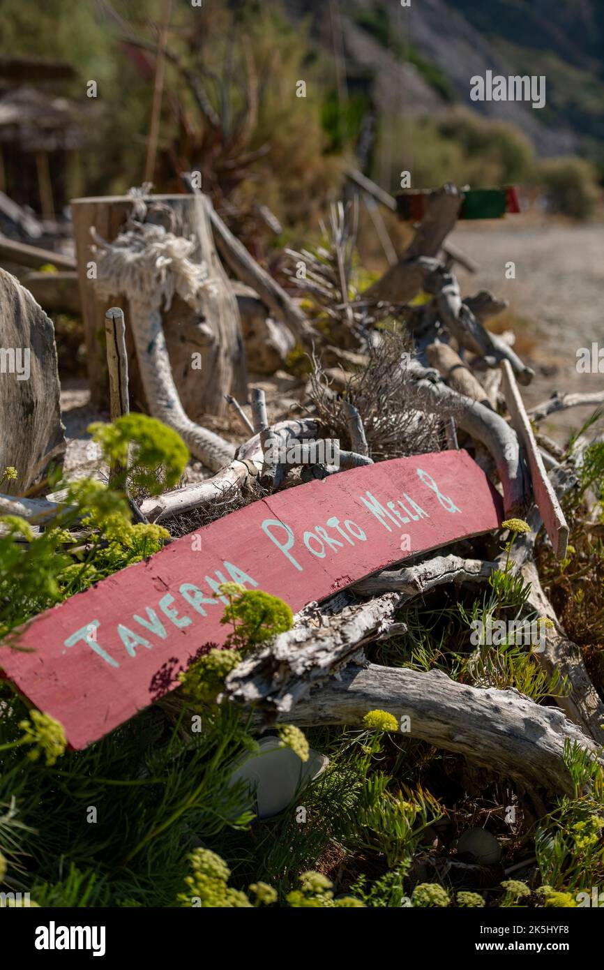 greek taverna sign washed up on a sandy beach on zante or zakynthos, flotsam and jetsam on beach in greece with wooden signs and debris high and dry. Stock Photo