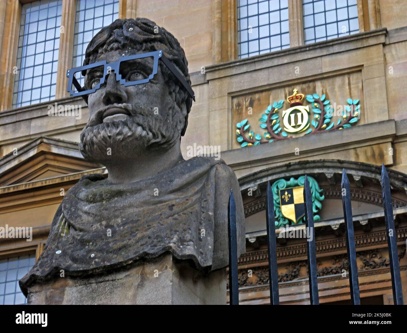 Sheldonian Theatre, stone heads, Emperor Heads, The, Oxford Emperors, or,  The ,Twelve Apostles, with glasses, Broad St, Oxford,England, UK Stock Photo