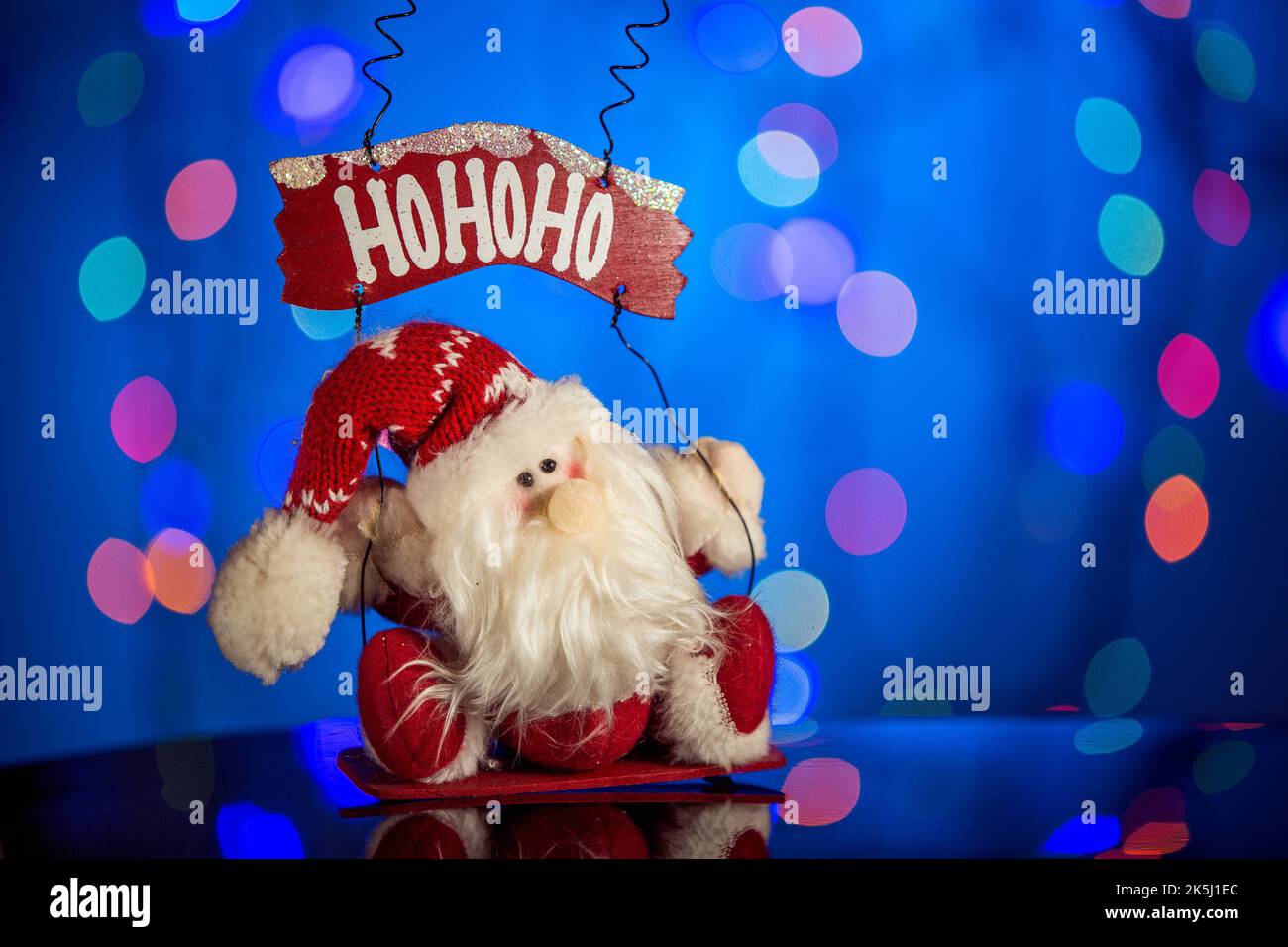 Jolly santa claus toy on sparkling and fabulous bokeh background with
