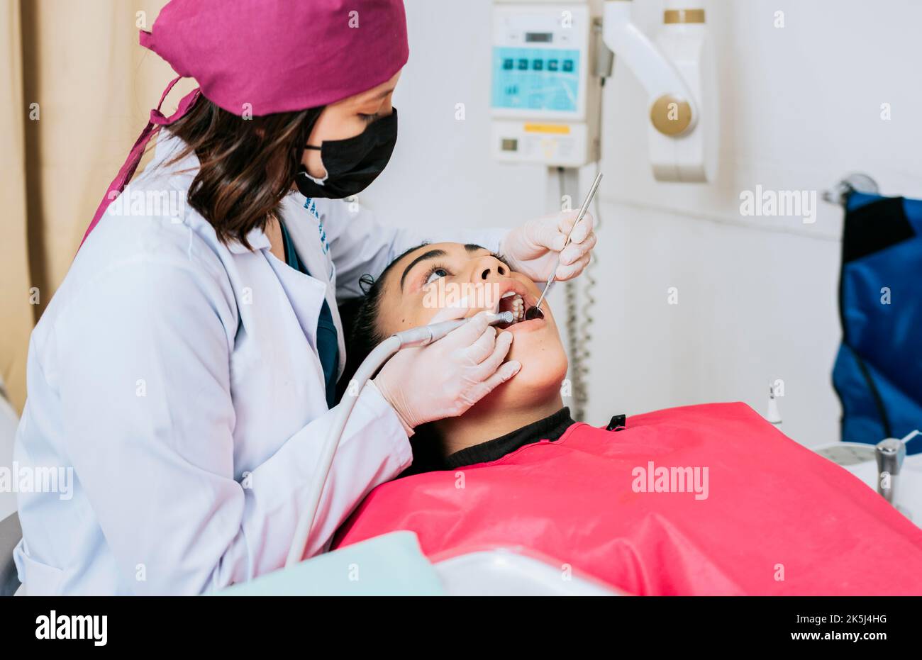 Dental specialist cleaning the teeth of a female patient. Professional dentist cleaning a female patient's mouth, Female dentist cleaning and Stock Photo