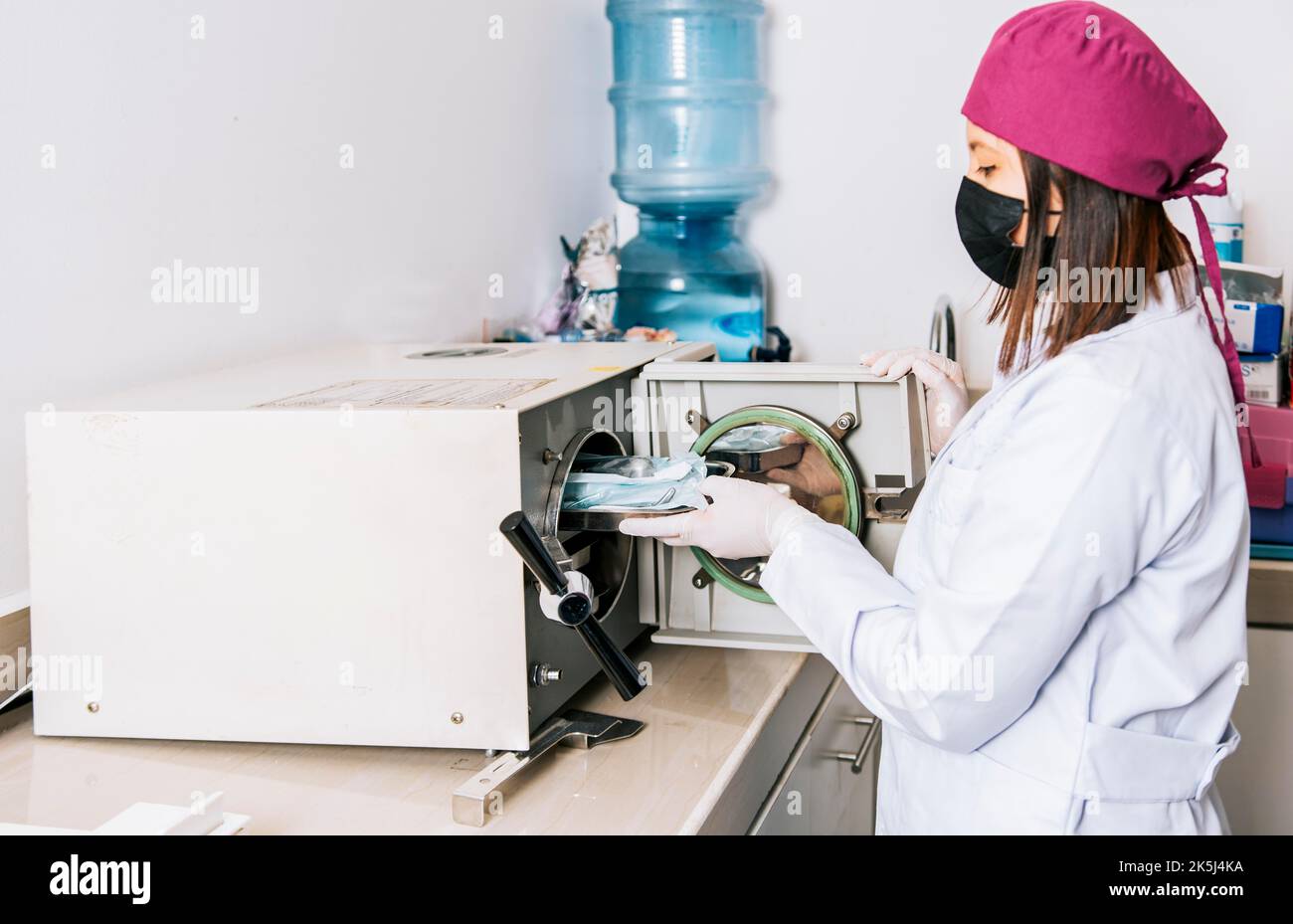 Hands of dentist sterilizing tools with autoclave, Dentist with dental