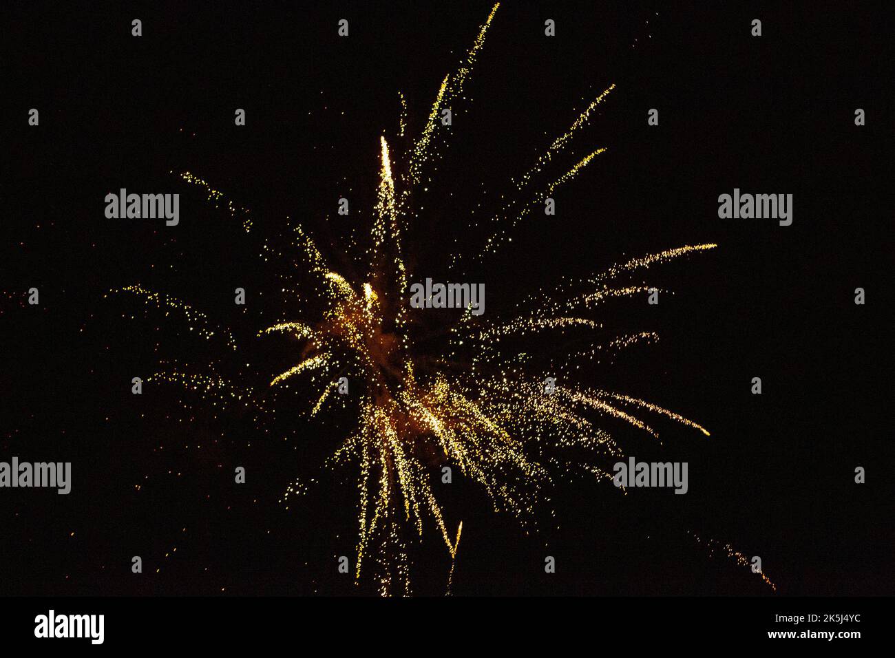 New Year's Eve fireworks night sky with yellow and golden sparks Stock