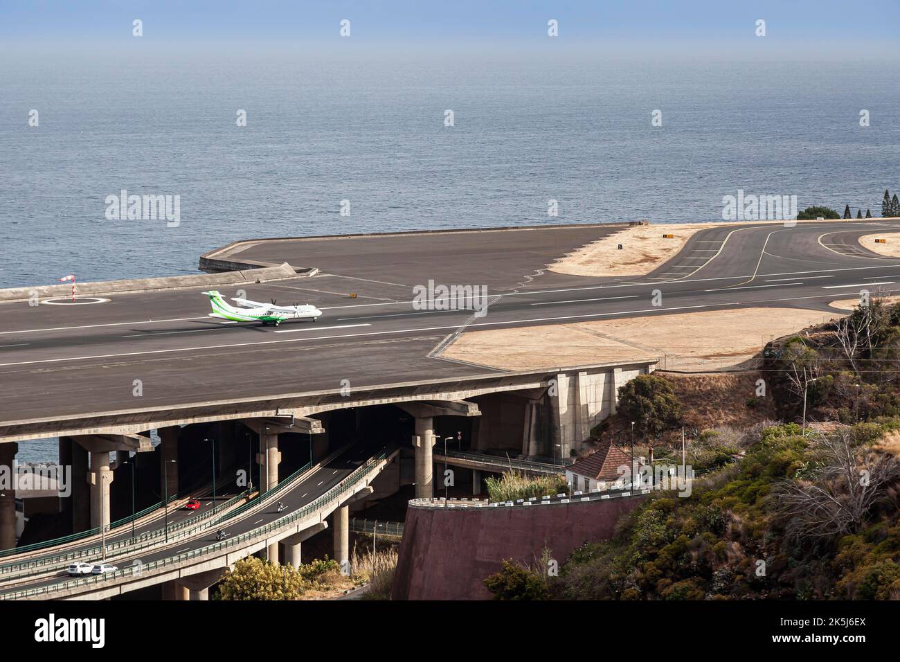 ATR72 approaching the runway of Madeira Airport LPMA, also known as Funchal Airport and Santa Catarina Airport, next to a busy highway, Santa Stock Photo