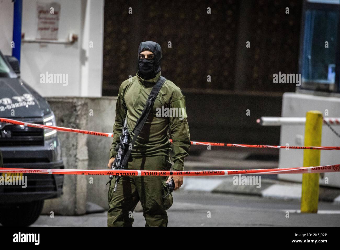 Jerusalem, Israel. 08th Oct, 2022. A memeber of the Israeli Security Forces stands at the scene, where two of his teammates seriously injured after a shooting attack at Shaufat Palestinian refugee camp checkpoint. Credit: Ilia Yefimovich/dpa/Alamy Live News Stock Photo