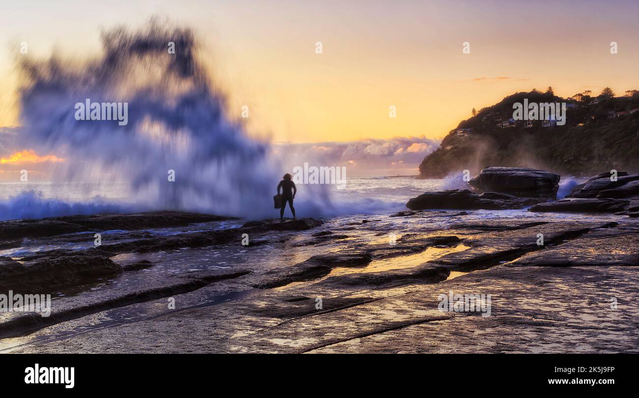 Splash of huge wave hitting rocks on Whale beach of Pacific coast in