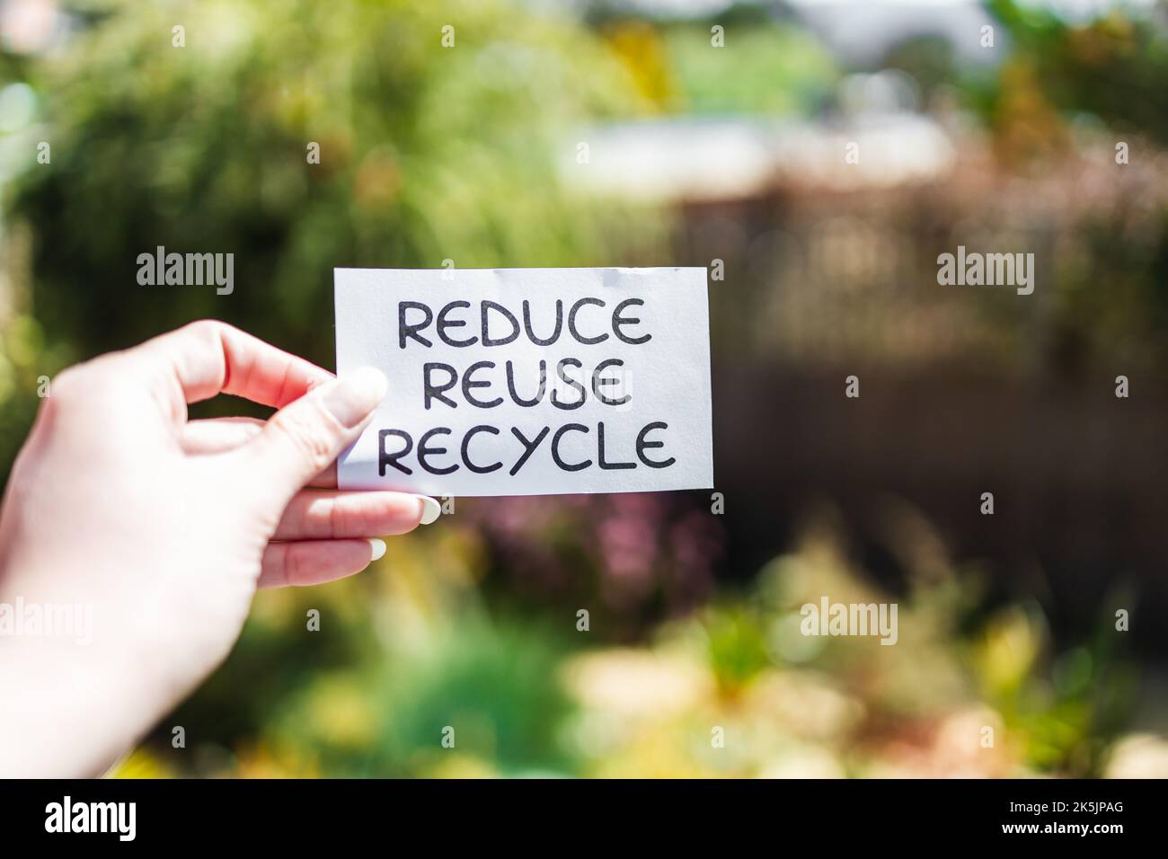 reduce reuse recycle sign in front of backyard bokeh, concept of ...