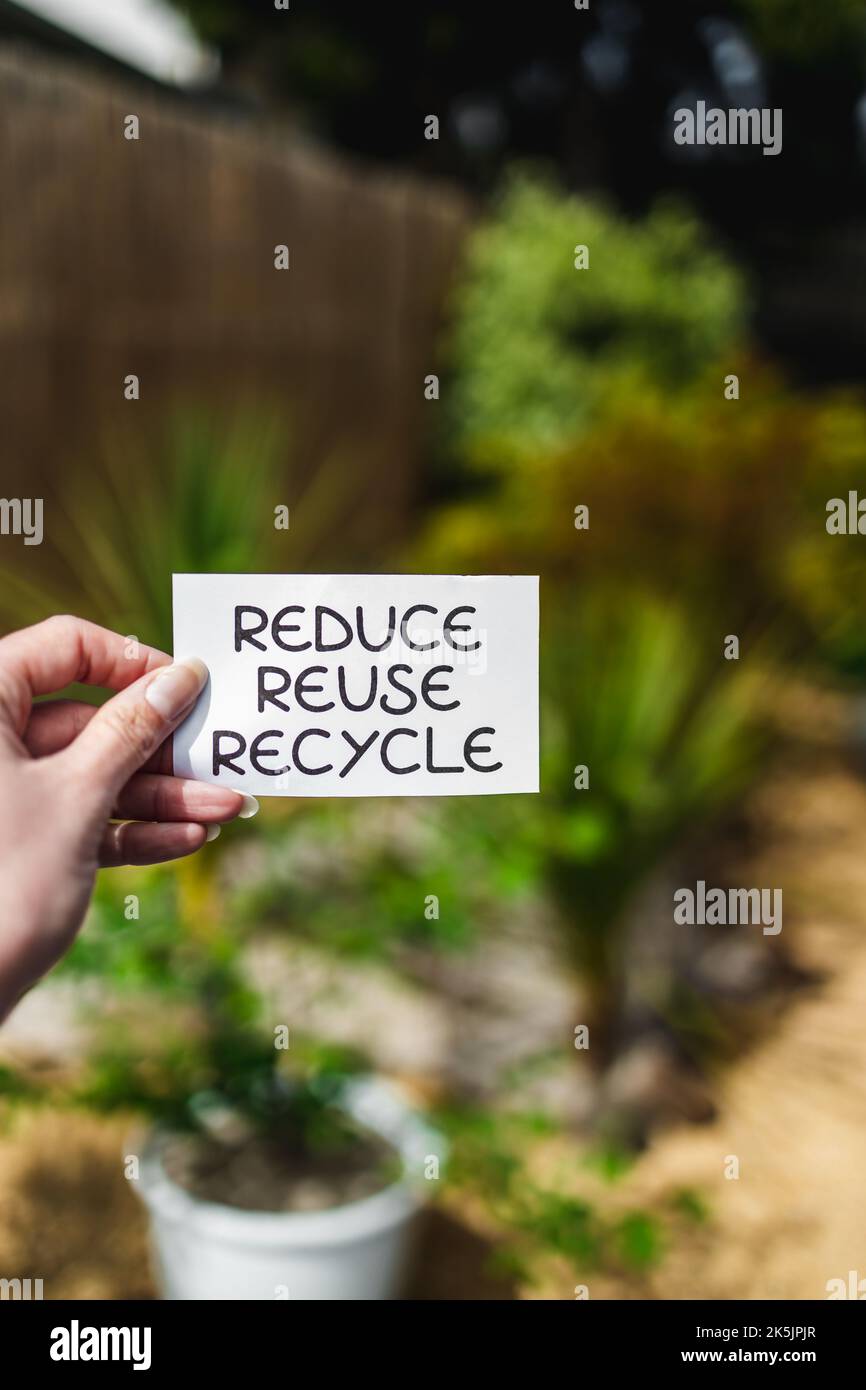 reduce reuse recycle sign in front of backyard bokeh, concept of ...
