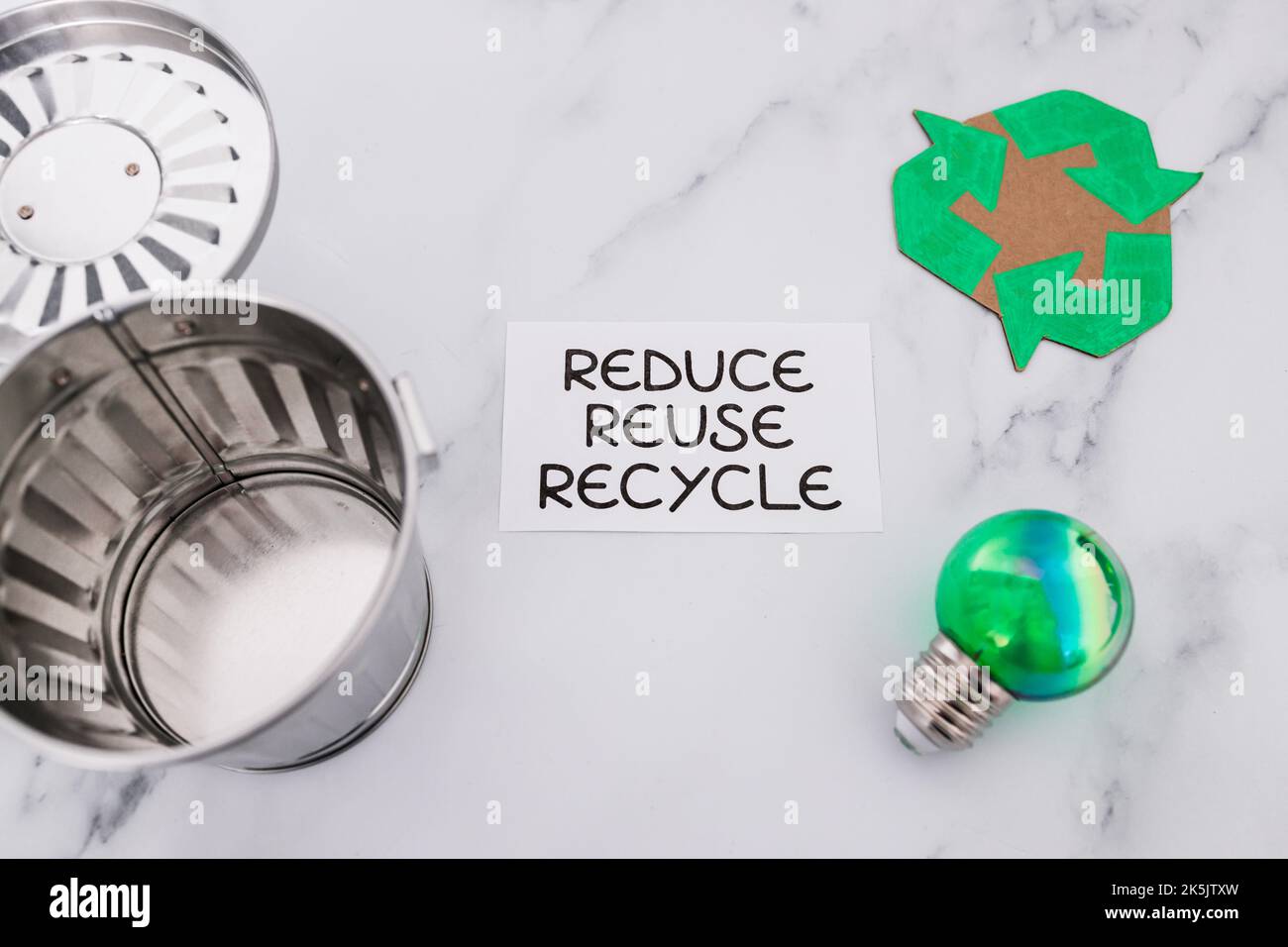 reduce reuse recycle sign with mini trash can next to green light bulb ...
