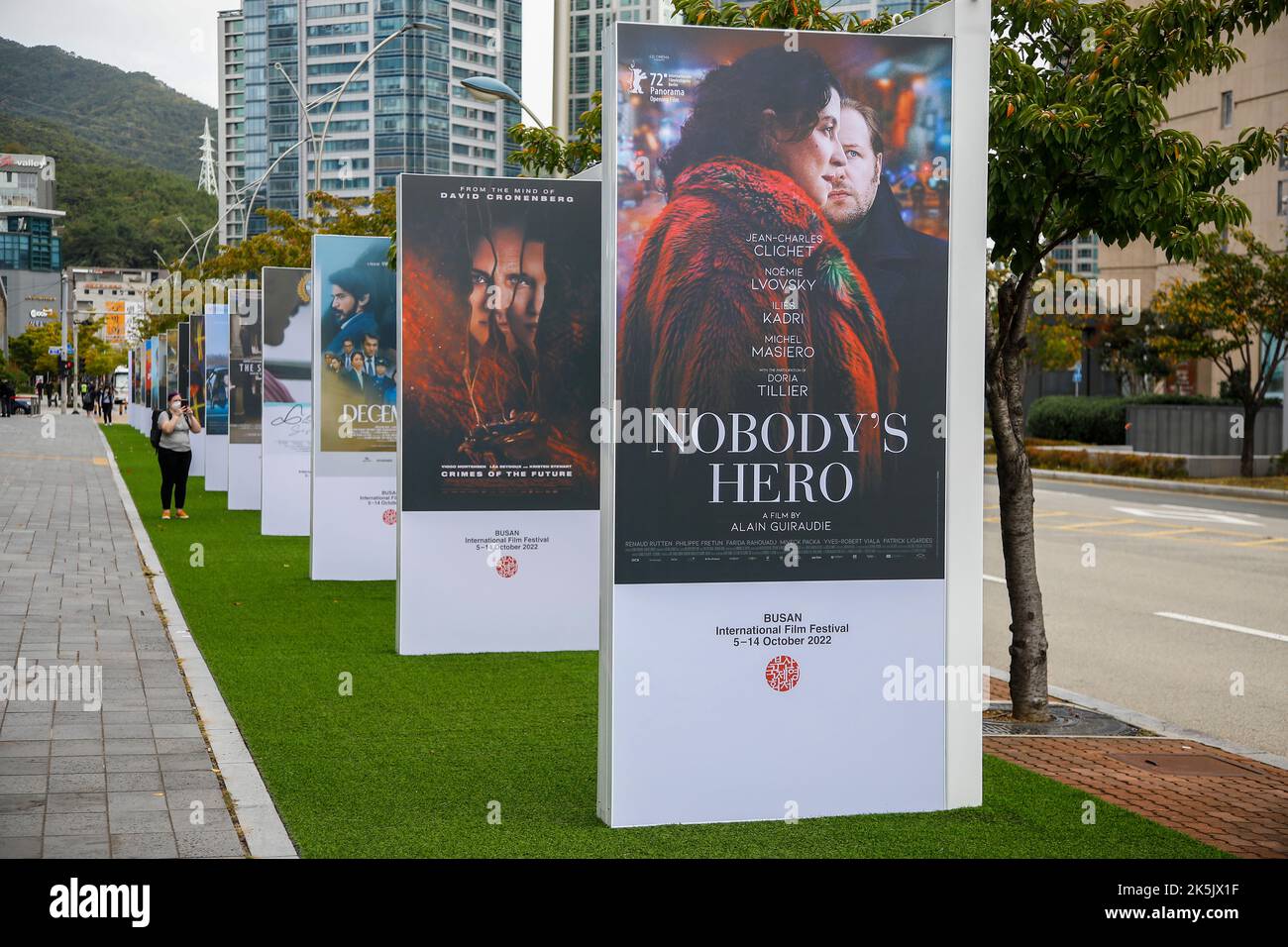 Oct 5, 2022-Busan, South Korea-Visitor take a picture a  event film poster at near cinema square in Busan, South Korea. Stock Photo